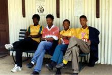 4 young men sitting on a bench